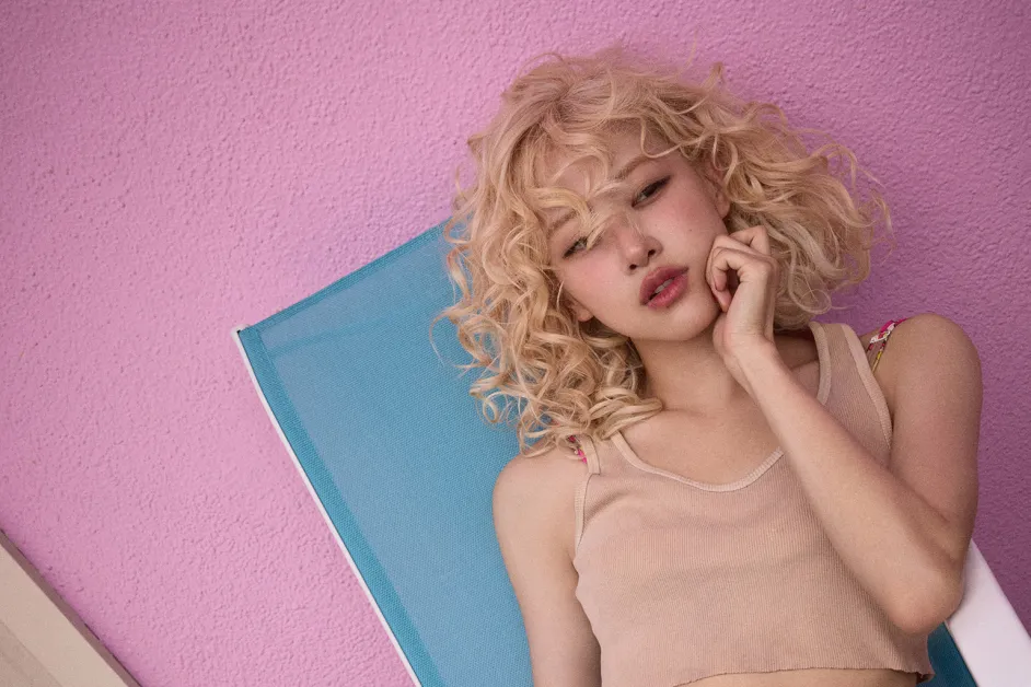 Artist with blonde curls lying on a sun lounger